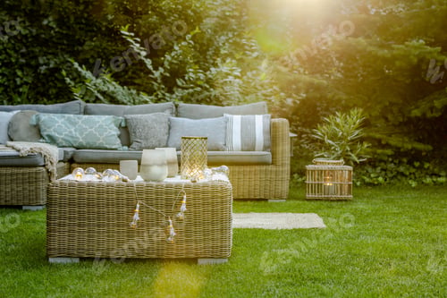 Preview: Grey pillows on trendy wicker L shape sofa in the green garden