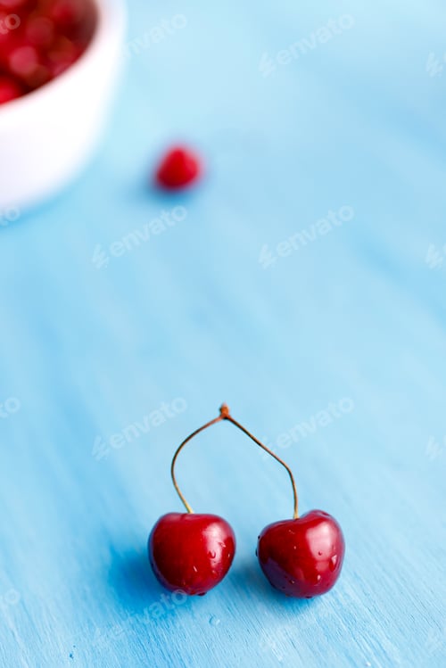 Preview: background of cherries and leaves on blue