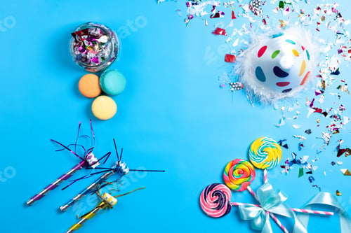 Preview: a top view lollipops and decors colorful macarons funny cap birthday whistles isolated on the blue