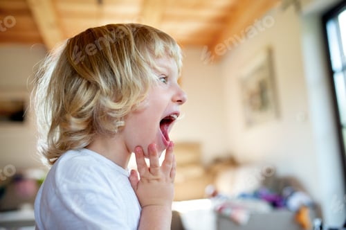 Preview: Portrait of small boy with open mouth indoor at home