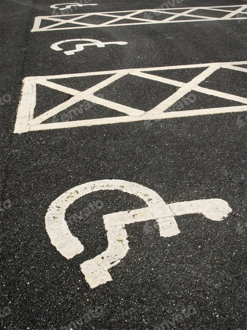 Preview: Handicap parking sign painted yellow on the street. Special parking space reserved for wheelchairs.