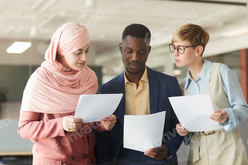 Preview: Ethnic Business Team Reading Documents in Office