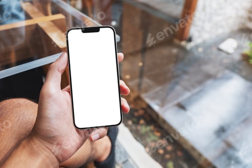 Preview: Mockup image of a man holding mobile phone with blank white screen in cafe