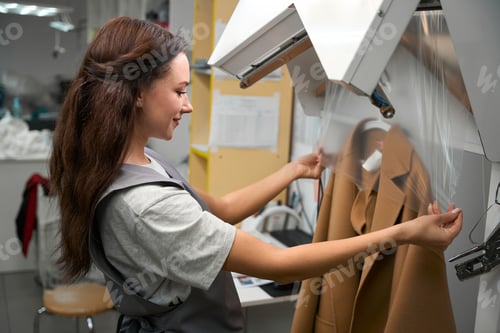 Preview: Woman putting clean and dry coat into cellophane bag