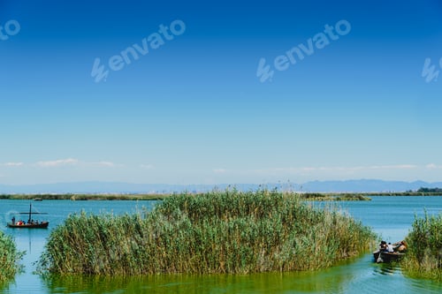 Preview: Tourists sailing on a touristic tour in a traditional boat on the Albufera lake in Valencia