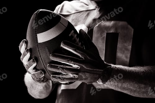Preview: American football player holding rugby ball