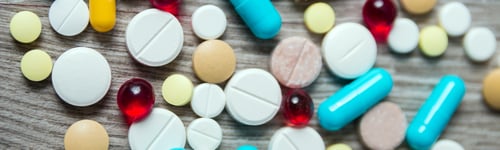 Preview: Banner of A lot of colorful medication and pills from above on grey wooden background.
