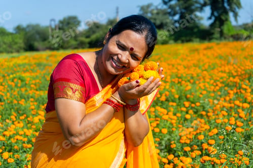 Preview: Indian woman in marigold field and enjoying nature.