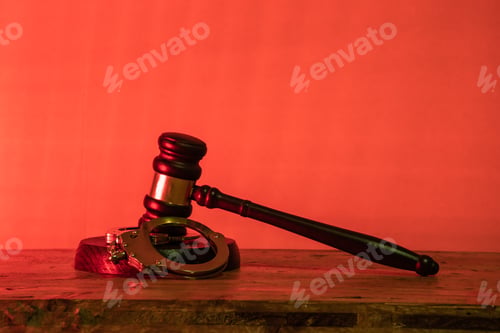 Preview: Gavel and handcuffs lie on a wooden table in a courtroom. justice, crime, legal