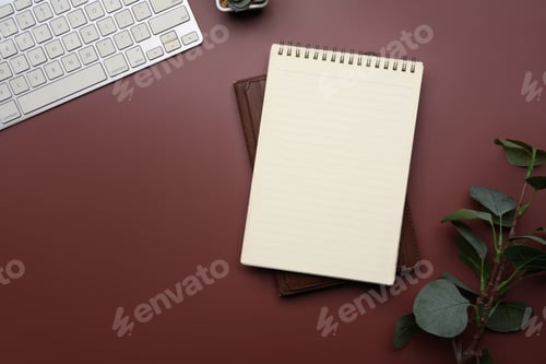 Preview: Stylish workspace with a blank spiral notebook, keyboard and on red background