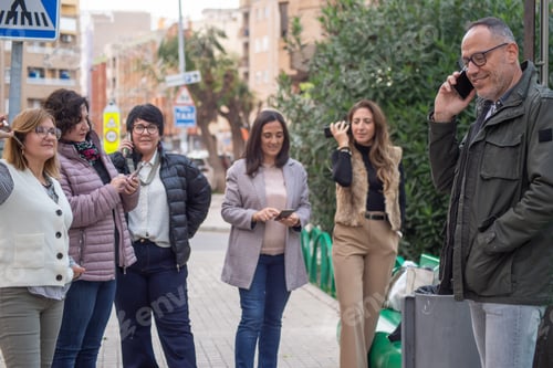 Vista previa: Grupo de personas mirando y hablando por teléfono al mismo tiempo al aire libre