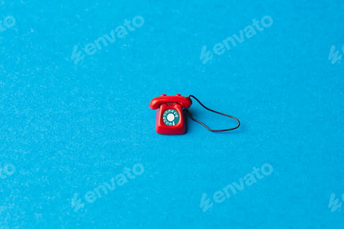 Preview: small red dial phone on a blue background