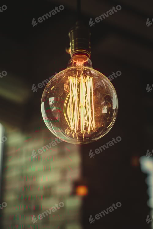 Preview: Glowing Lightbulb with Decorative Filament in Dark Setting