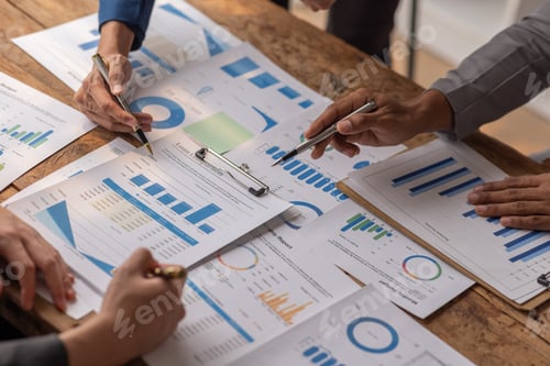 Preview: Group of confident business people point to graphs and charts to analyze market data, balance sheet,