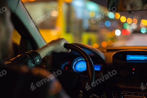 Preview: The man drive a modern car in the city. Evening night time