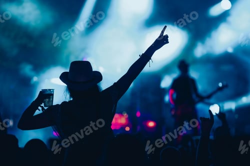 Preview: Silhouette of a woman with raised hands on a concert