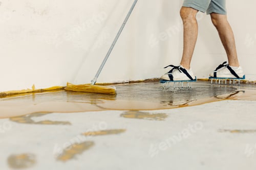 Preview: The worker applies yellow epoxy resin to the new floor