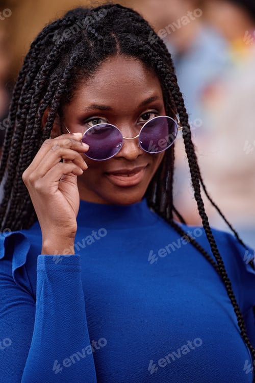 Vista previa: Beautiful african american woman with dreadlocks and sunglasses looking at camera