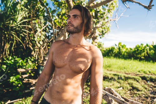 Preview: Athletic handsome man contemplating in tropics