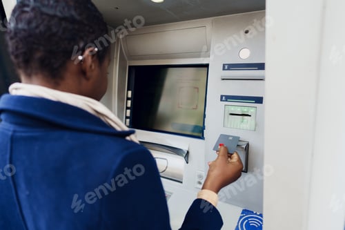 Preview: Young african woman withdrawing cash at the ATM