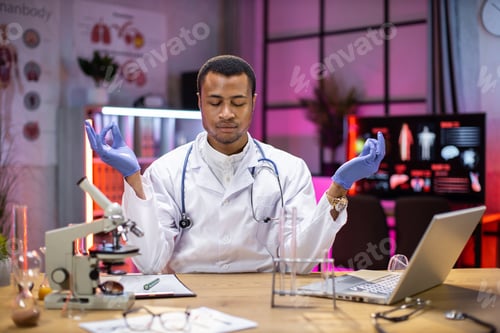 Preview: Yong african american male scientist relaxing practicing yoga wearing lab coat working in laboratory