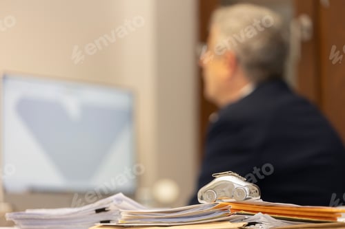 Preview: an office desk with a computer and many files stacked on it