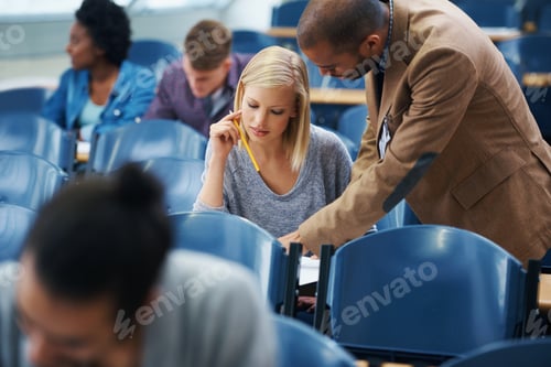 Vorschau: Eins-zu-Eins-Ausbildung. Aufnahme eines Hochschullehrers, der auf etwas in der Zeitung eines Schülers hinweist.