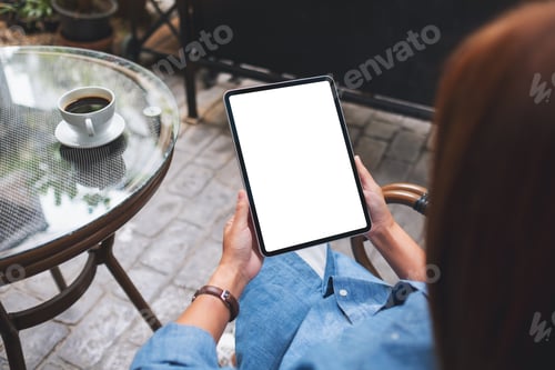 Preview: Mockup image of a woman holding digital tablet with blank white desktop screen in the outdoors cafe
