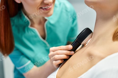 Preview: Young specialist performing a detailed dermatology examination on patient in clinic setting