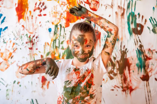 Preview: Portrait of happy young child playing with watercolor