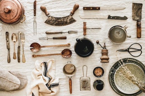 Preview: Kitchen utensils and tablewear over linen tablecloth, top view