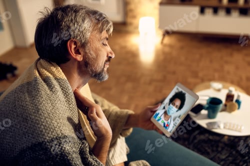 Preview: Sick man complaining about pain in his throat while having video call from doctor from home.