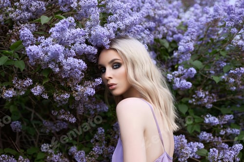 Preview: Beauty blonde woman in summer in a lilac Bush. Beauty Portrait of a girl in purple flowers