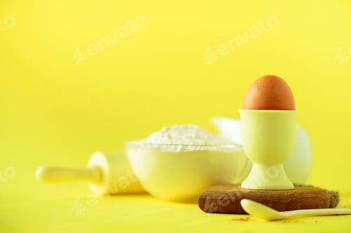 Preview: Healthy baking ingredients - butter, sugar, flour, eggs, oil, spoon, rolling pin milk over yellow