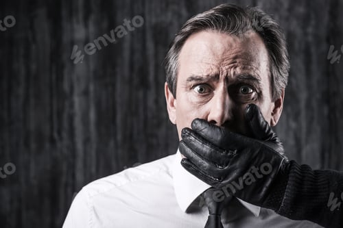 Preview: Shocked victim. Shocked businessman caught by a criminal holding hand on mouth of his victim