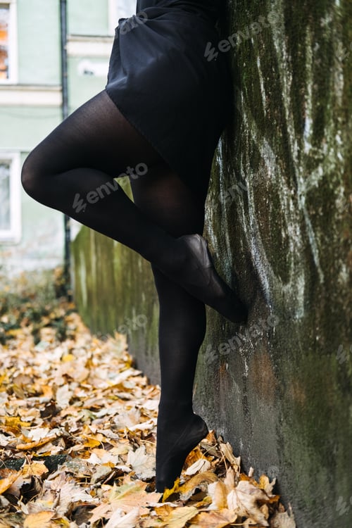 Preview: Ballerinas legs in pointe shoes outdoors in autumn street background. Ballerina Dancing in autumn