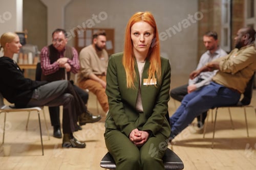 Preview: Troubled female in green suit sitting in front of camera