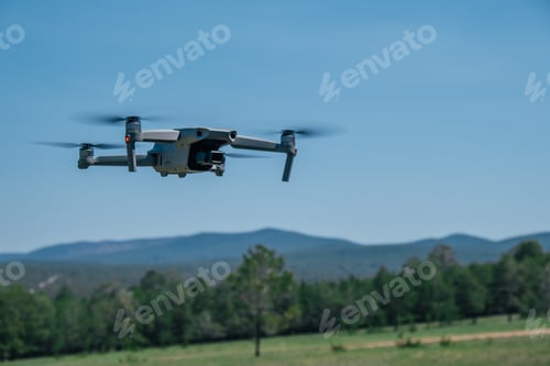 Preview: drone flies in the air in summer against the backdrop of mountains.