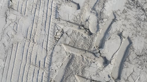 Preview: Sandy background with prints of wheels and footprints