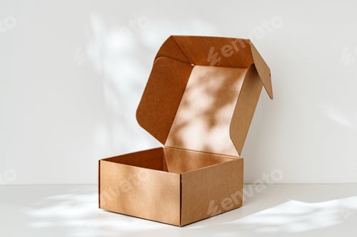 Preview: An open cardboard box rests on a bright white surface with soft shadows highlighting its edges and