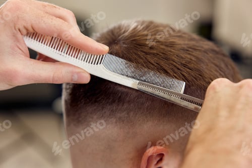 Preview: hairdresser does haircut for caucasian bearded man