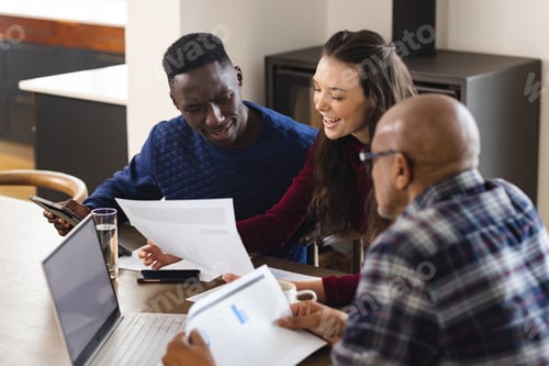Preview: Diverse couple and biracial male financial advisor using laptop and discussing documents at home