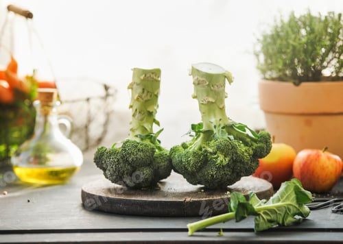 Preview: Two whole broccoli heads on kitchen table with ingredients: