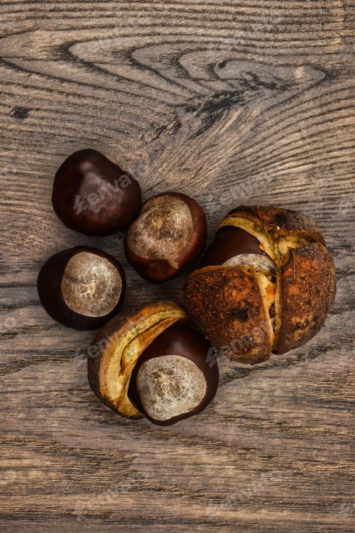 Preview: Vertical top view of shelled and unshelled chestnuts on a wooden surface