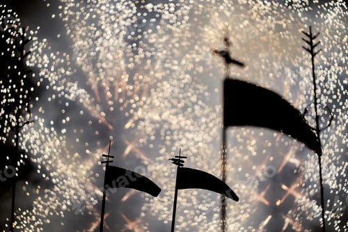 Preview: silhouette of a scythe and fireworks in the background. selective focus out-of-focus background