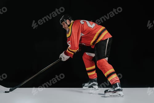 Preview: side view of professional sportsman playing hockey on black