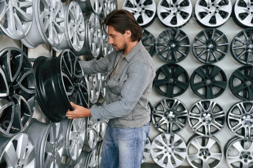 Preview: Many of the disks on walls. Man is in the tire fitting car service