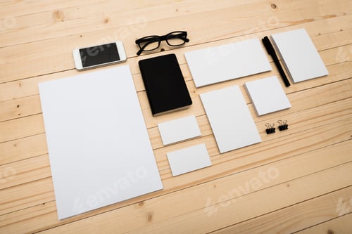 Preview: Collection of stationery items arranged on a wooden surface in a minimalist workspace setting