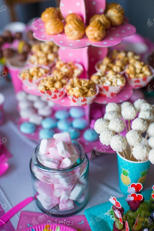 Preview: Marshmallow, sweet colored meringues, popcorn, custard cakes and white cake pops on desert table