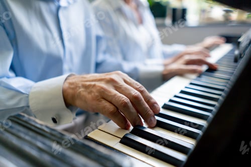Preview: hands close up elderly people sitting at the piano together playing a melody learning new chords old